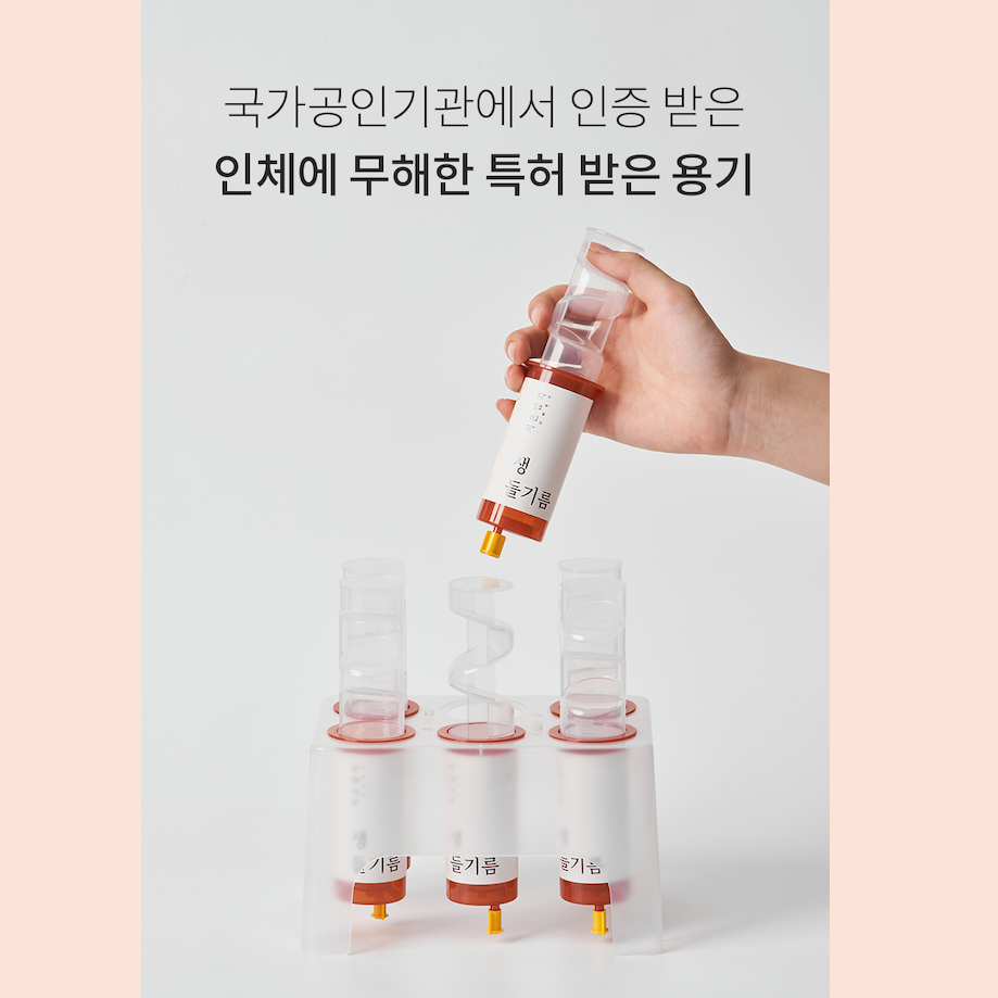 Hand taking Perilla Oil Bottle out of Plastic Container.